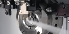 Grooving tool in action with coolant on CNC lathe